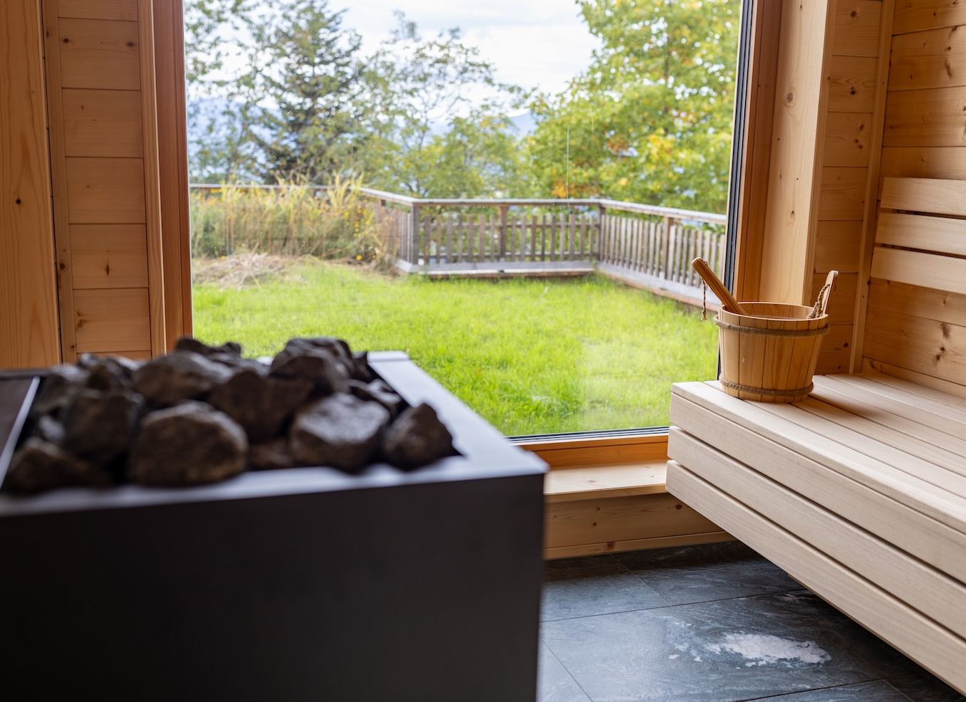 Blick aus der Sauna durch das große Fenster ins Grüne