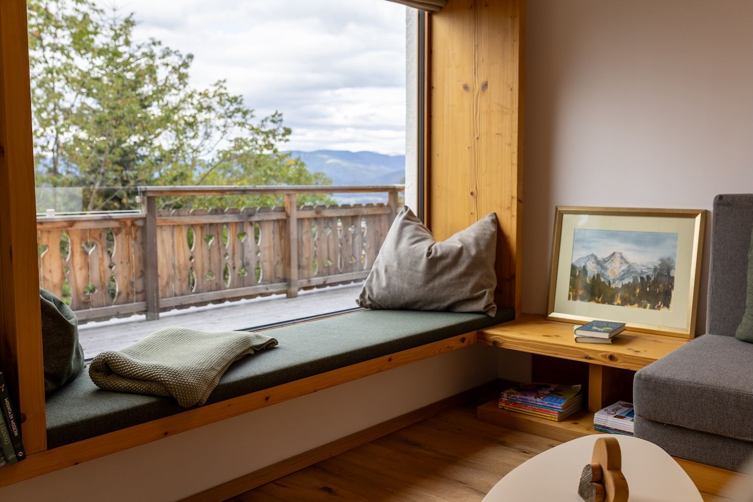 Fensterbank-Leseplatz mit grünem Polster und Bergblick