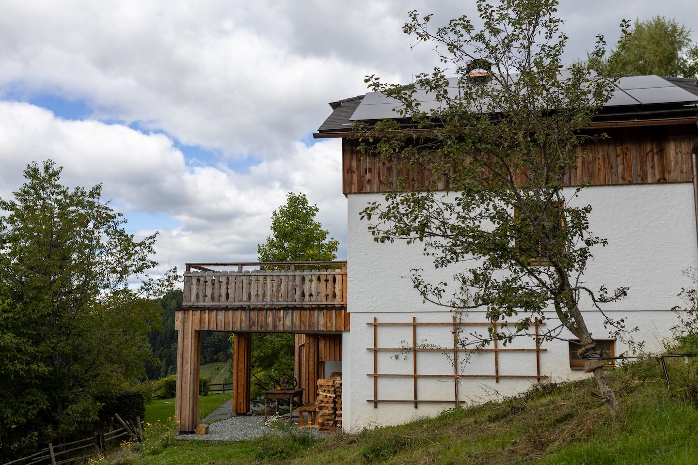 Seitenansicht des Hauses mit Balkon und altem Apfelbaum